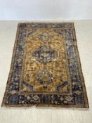 A Shiraz carpet with central stylised hooked medallions on a sand ground within sapphire multiple