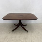 A Georgian mahogany dining table with tilt-top action on quadruped swept supports terminating in