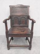A 17th century oak wainscott armchair with carved panelled back on stretchered supports. H.102cm