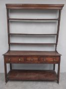 An 18th century oak dresser with upper open platercak section above base fitted with three drawers
