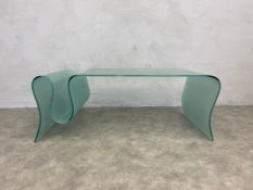 A frosted plate glass coffee table of scrolling form creating an integral magazine section. H.46 W.