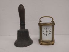 An 18th century bronze hand bell and a 19th century brass carriage clock. Bell H.15 Dia 10cm (