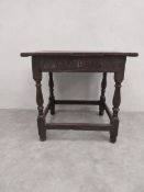 A 17th century oak side table with cleated plank top above carved frieze on turned stretchered