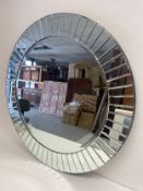 A large contemporary wall mirror with bevelled glazed panels. Dia.101cm.
