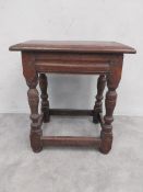 An 18th century oak joint stool the moulded plank top on turned stretchered supports. H.48 W.46 D.