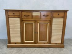 A contemporary hardwood sideboard, three frieze drawers with panel doors and tambour shutters