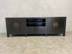 A Chinese lacquered low sideboard fitted with cupboards, drawers and HI-FI or TV lead apertures to