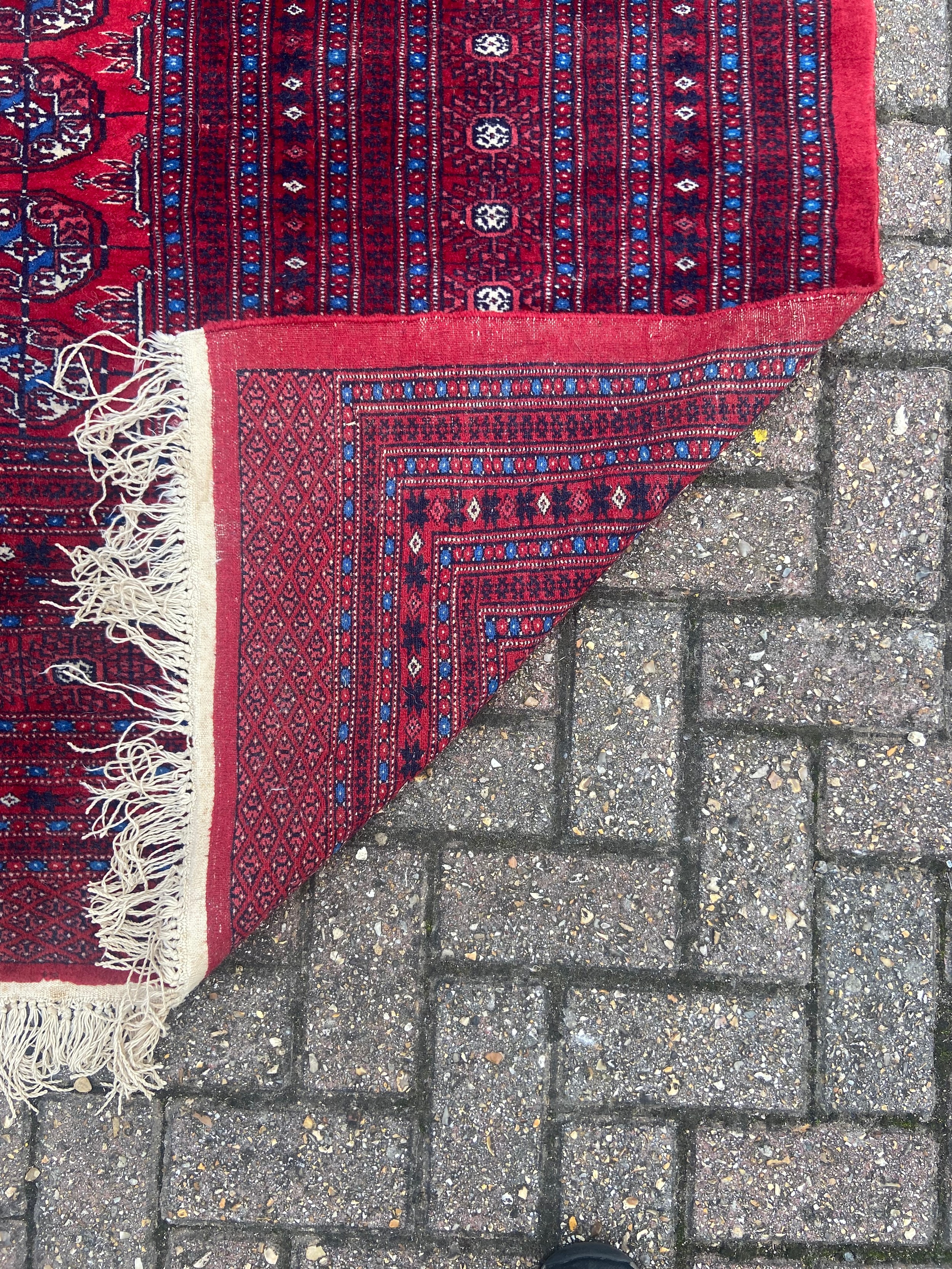 A large bokhara carpet with repeating gul motifs across a burgundy field within multiple stylised - Image 3 of 4