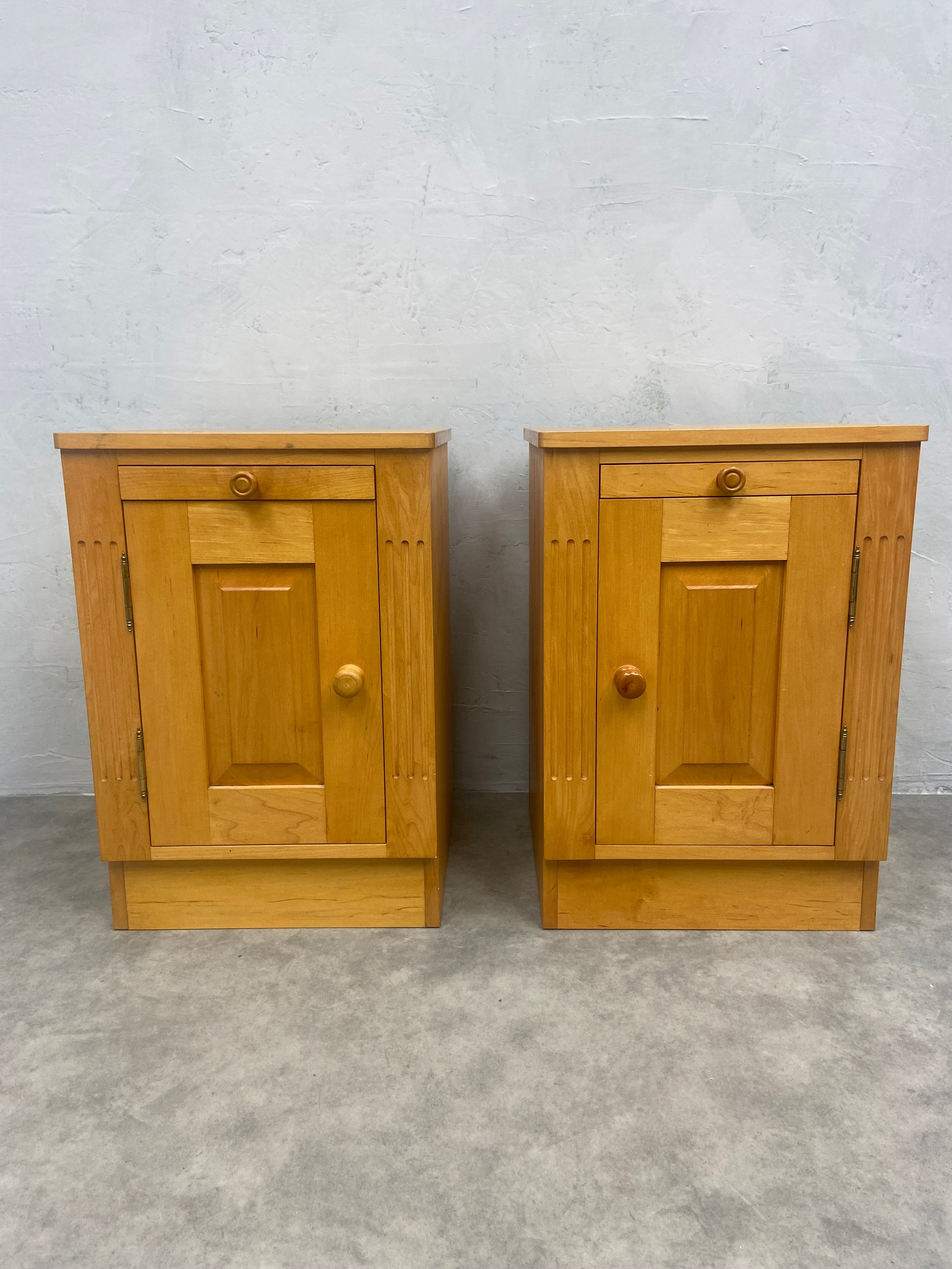 A pair of cotemporary maple bedside cabinets fitted with slides above panel doors. H.60 W.41 D.41cm.