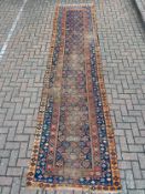 A hand knotted Shirvan runner with a repeating geometric pattern on a midnight ground within