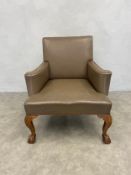 A large Georgian style library armchair in studded leather upholstery on shell carved ball and