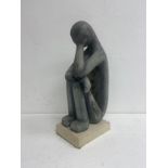 A carved stone seated figure in the modernist style signed and dated Makis to the base. H.
