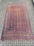 A hand knotted Shirvan carpet with repeating stylised flowerhead motifs across a midnight ground