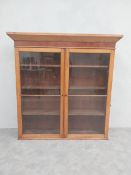 A 19th century light oak and mahogany library bookcase section with glazed doors enclosing