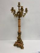 A late 19th century French ormolu and marble six branch table candelabra on cherub supports
