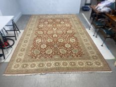 A large Ziegler style carpet with scrolling foliate pattern across the burgundy field within