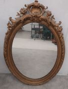 A 19th century wall mirror in a giltwood and gesso frame with scrolling Rococo cresting. 94 x 65cm
