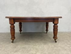 A late 19th century flame mahogany extending dining table with wind-out mechanism and two extra