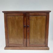 An early 19th century mahogany table top stationery or collector's cabinet with panel doors