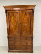 A 19th century mahogany linen press having a moulded cornice with carved corbels over two panelled