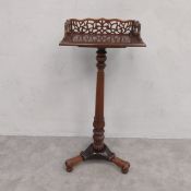 A Regency style book table with pierced galleried back on turned pedestal resting on a triform base.