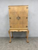 An early to mid 20th century early Georgian style bleached walnut cocktail cabinet with peach