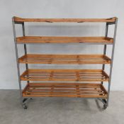 A vintage bakers rack with five slatted shelves on metal frame with casters. 127 x 122 x 35cm