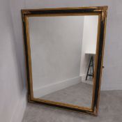 A large contemporary wall mirror with bevelled plate in gilt and ebonised foliate frame. 140 x