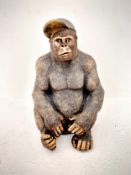 A seated gorilla figure wearing baseball cap in moulded composite ceramic. 60 x 40 x 35cm