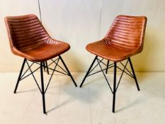 A pair of retro styled dining chairs in ribbed leather upholstery on tubular metal bases. 85 x 46
