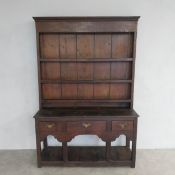 An 18th century oak dresser of compact size, the upper plate rack section above base fitted with