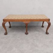 A C.1900 Georgian style walnut long stool with drop-in tapestry seat on shell carved cabriole
