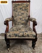 A William IV mahogany framed library armchair having a carved top-rail and needlework upholstered