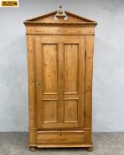A C.1900 pine wardrobe with broken pediment and ball and spire finial over a pair of panelled
