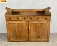A late 19th century pine washstand or dry sink having a shaped gallery back and green vinyl lined