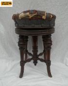 A Victorian mahogany revolving piano stool with a circular leather height adjustable top raised on