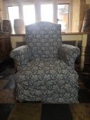 A 19th century armchair on turned mahogany supports. with floral loose cover. H.99 W.84cm.