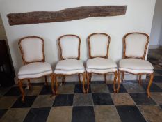 A set of four faux bamboo dining chairs fitted with squab cushions on cabriole supports.