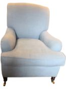 A Howard style armchair upholstered in pale blue calico on turned mahogany supports terminating in