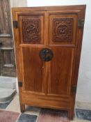 A Carved Chinese teak linen or hall cabinet with panel doors enclosing a fitted interior. H.163 W.88