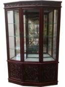 A Chinese carved and lacquered two section cabinet with shaped front and uplit and downlit display