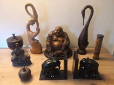 A miscellaneous collection of carved items to include a seated buddha and ebony elephant bookends.