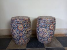 A pair of Chinese ceramic garden stools in polychrome foliate glaze on a blue ground. H.47cm.