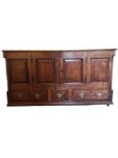 A Georgian oak side cabinet with panel doors above three base drawers on block feet. H.78 W.150 D.