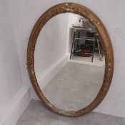 A late 19th century oval wall mirror in giltwood and foliate gesso frame. 92 x 65cm