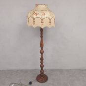 A vintage turned mahogany standard floor lamp of baluster form with embroidered needlework silk