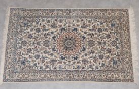 A Persian Nain carpet with central medallion and allover scrolling foliate field over a beige ground