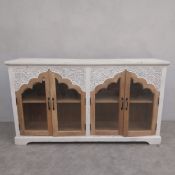 A contemporary sideboard with white painted plank top over a a pair of carved and shaped Arabesque