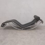 A vintage leather upholstered LC4 style chaise longue on a bent tubular chrome frame in the manner