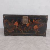 A vintage Oriental black lacquered papier-mache trunk or chest hand decorated with stylised lotus